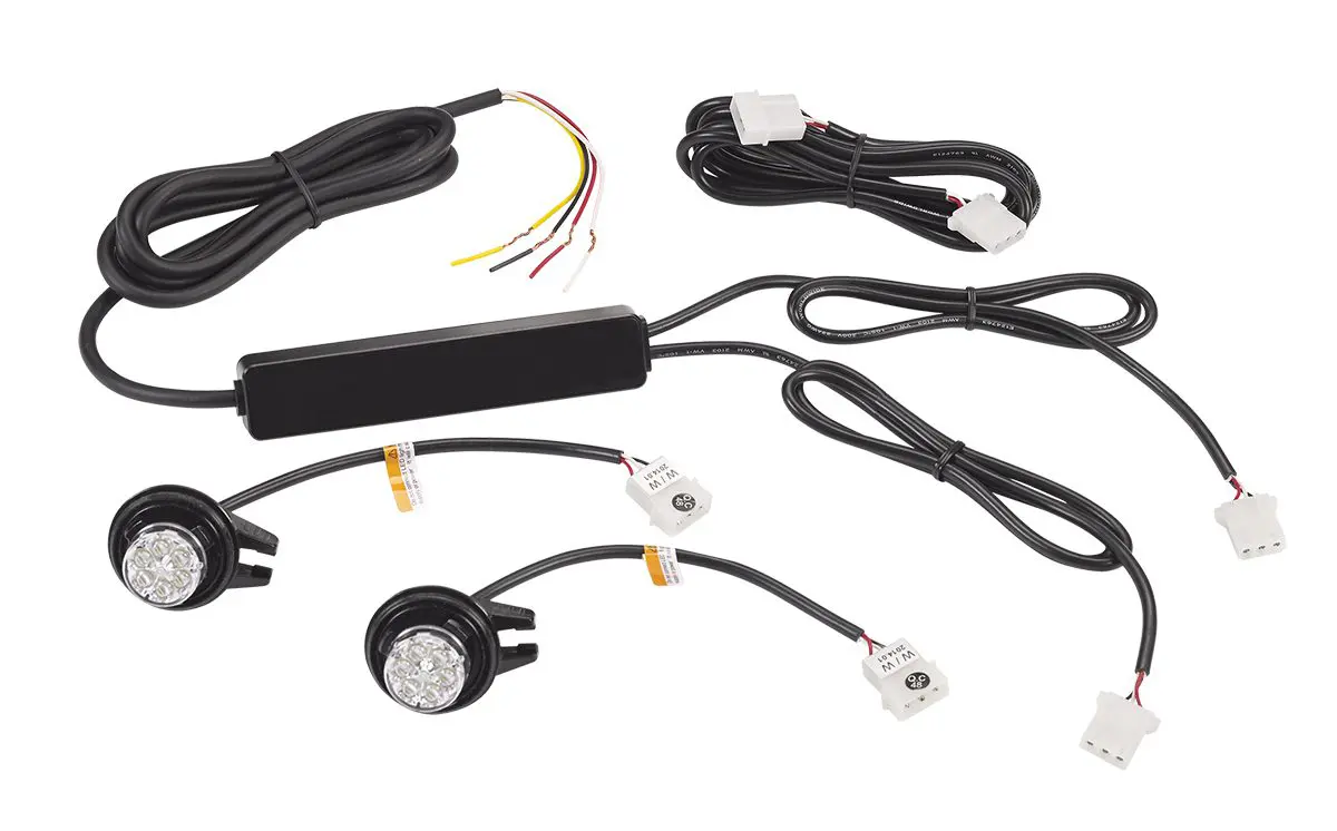 LED lighting kit with two round lights, wiring harnesses, connectors, and a control unit, arranged on a white background.