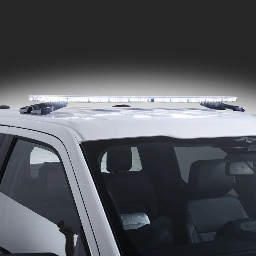 An Allegiant Serial Light Bar by FedSig is mounted on a white vehicle, shining brightly against a dark background.