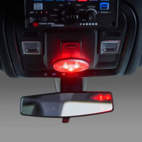 Dashboard with control panel, red glowing light, and rearview mirror.