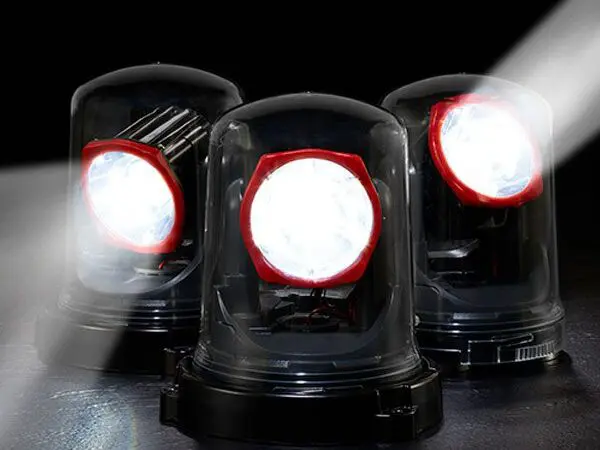 Federal Signal beacon emergency strobe lights are illuminated in a dark setting, casting bright white beams in different directions.