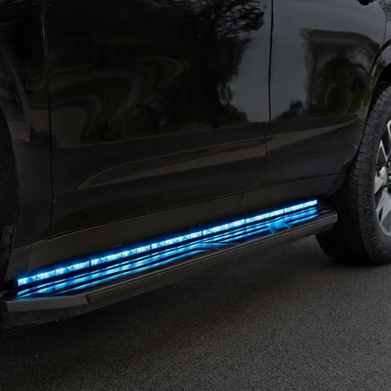 A police vehicle with illuminated blue LED lights installed along the side step, parked on a paved surface.
